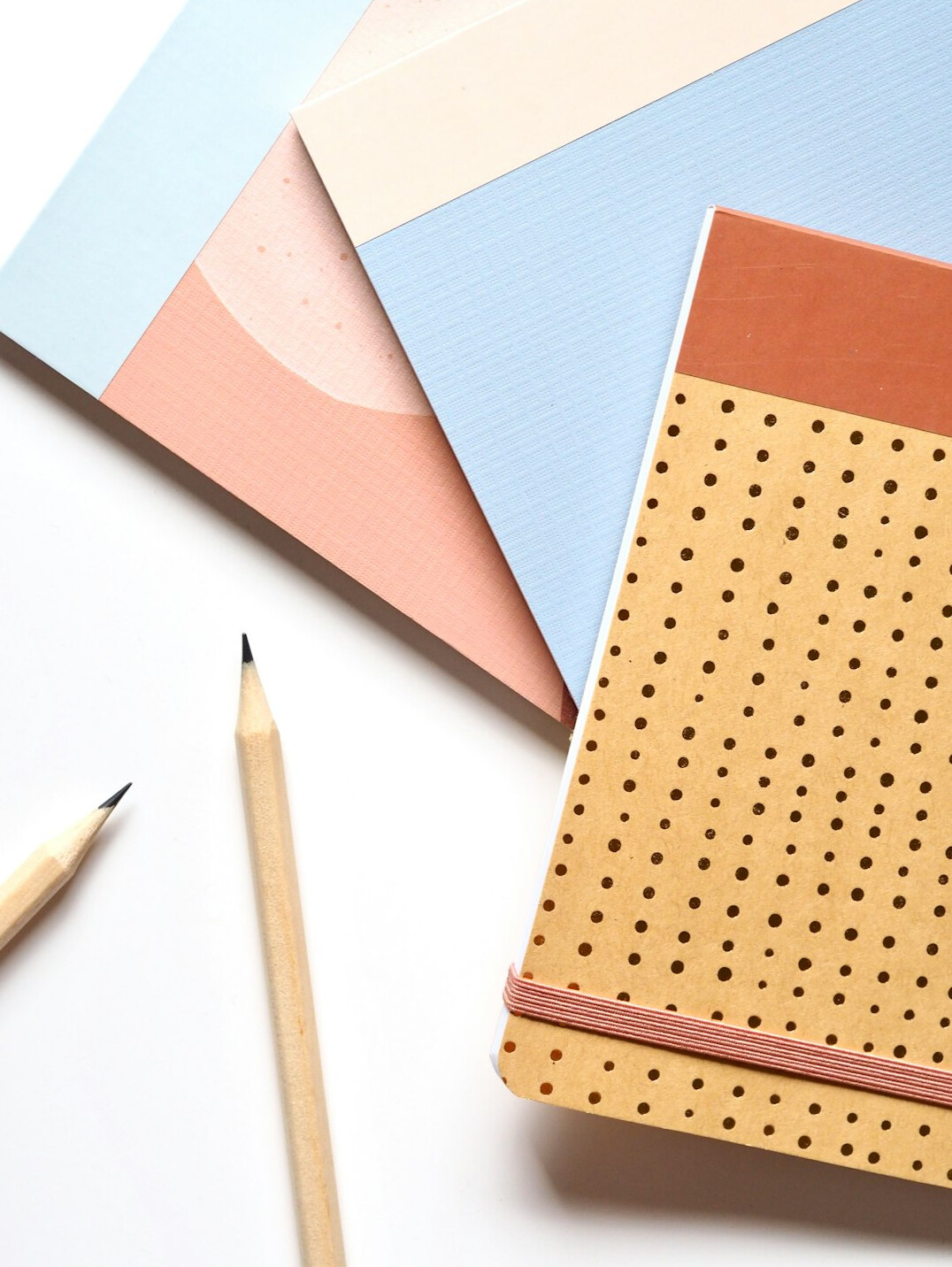 Notebook, coffee cup and laptop on a bright wooden desk
